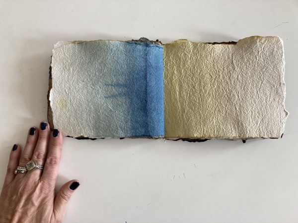 a hand touching handmade book