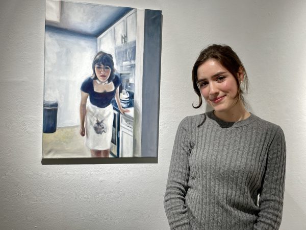 picture of Laura Lucas standing beside her self-portrait, "Fade to White."