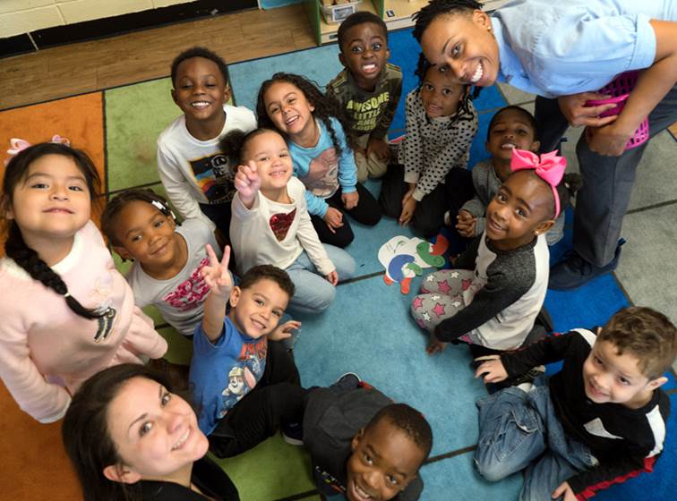 Diverse young students with their teachers